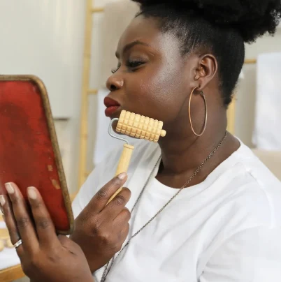 Anna Gomis, fondatrice de la Maison de Beauté Nawar, pendant un soin du visage au rouleau en bois