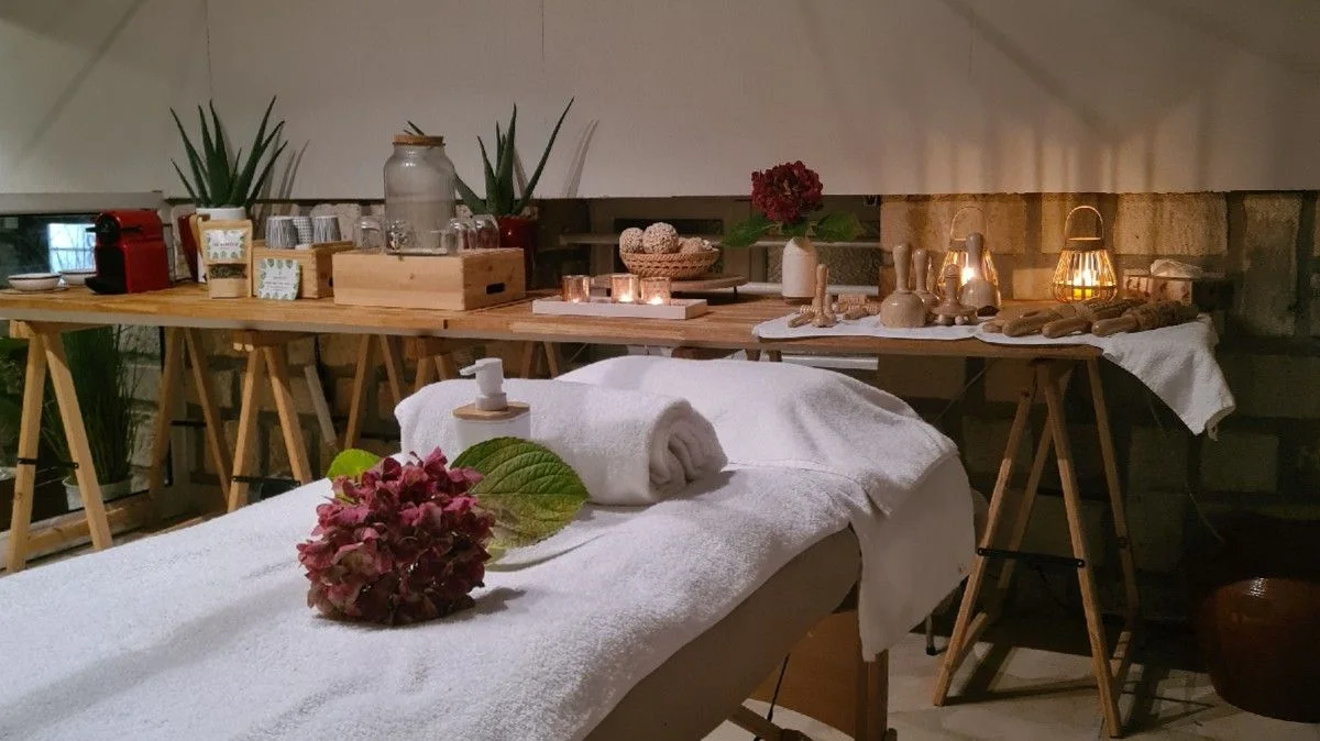La cabine de la Maison de Beauté Nawar : table de soin, serviettes, bougies et outils en bois